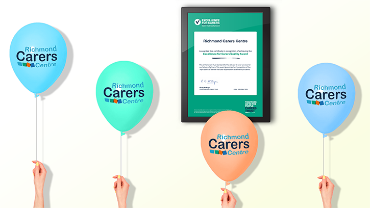 Image shows a framed certificate of the Excellence for Carers award with Richmond Carers Centre branded balloons